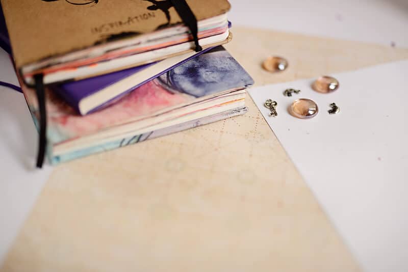 three art journals on a desk