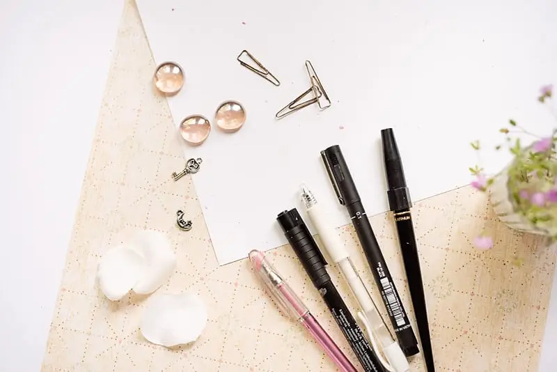 A photo of pens: black, white and pink.