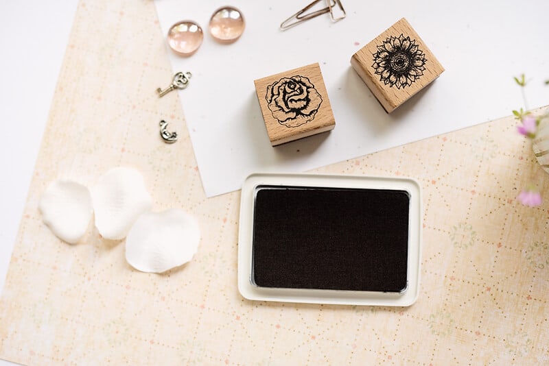 a photo of two flower stamps and a black ink pad