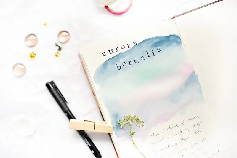AN ART JOURNAL PAGE SAYING: AURORA BOREALIS. IT'S AN EXAMPLE OF MINDFUL ART JOURNALING WITH BUCKET LIST IDEAS