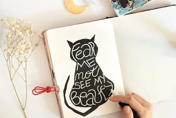 A PAINTED BLACK CAT AND A QUOTE