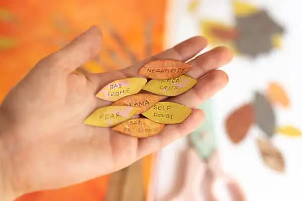 hand holding paper leaves with words