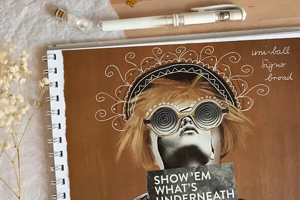 white pen doodles on a magazine page