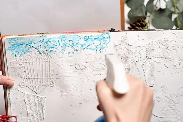 spraying water on art journal page