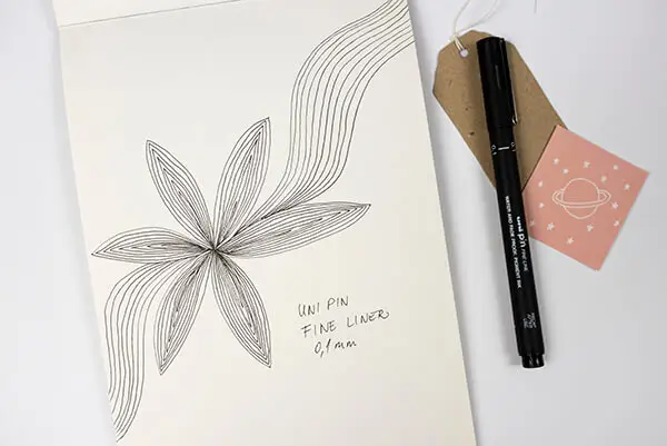 paper with flower doodles and a black pen