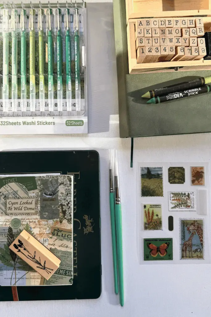 Flat lay of art journal supplies for beginners with pens, stamps, brushes, and decorated notebook.