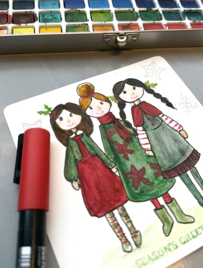 handmade greeting card with whimsical dolls dressed in green and red