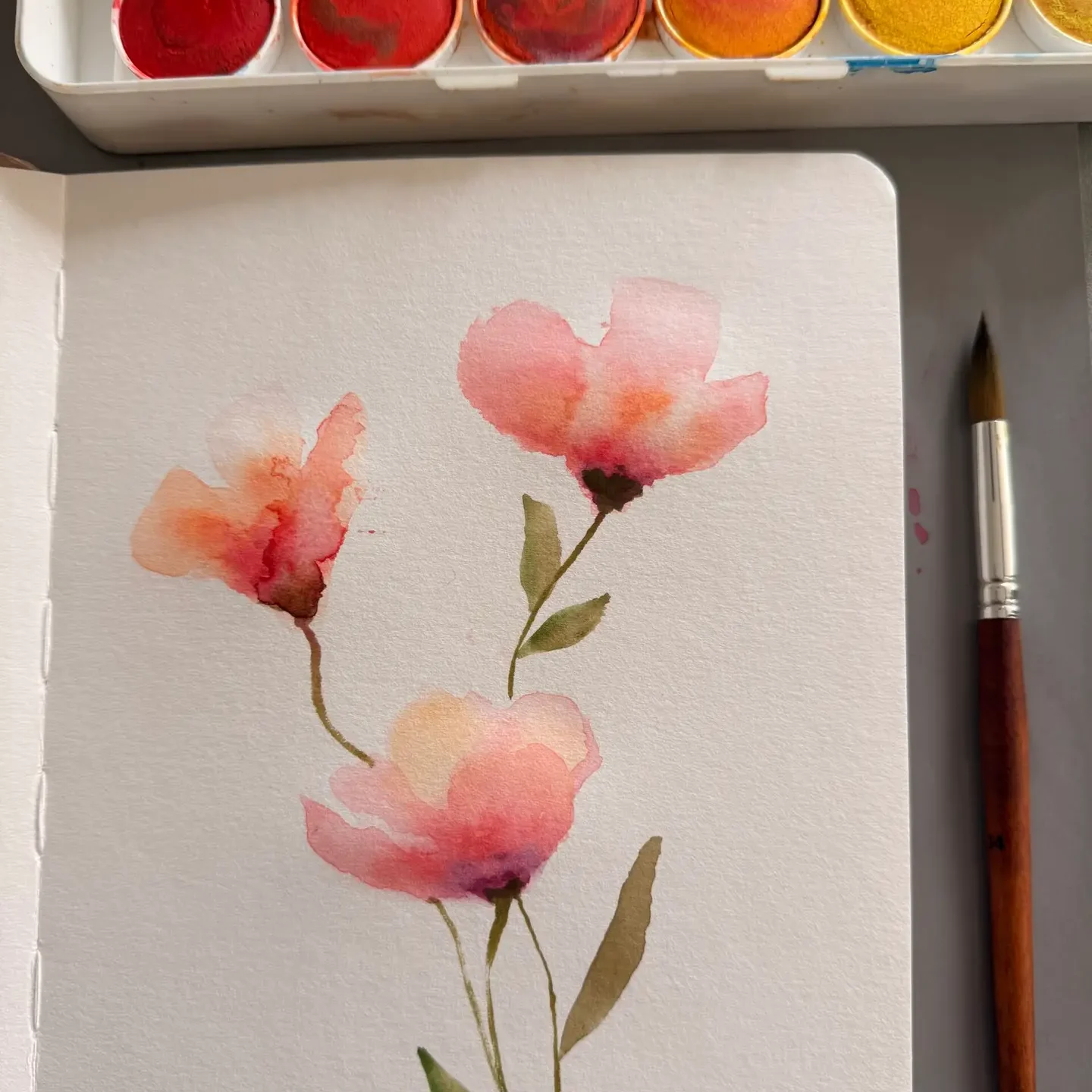 a handmade watercolor painting of flowers in an art journal