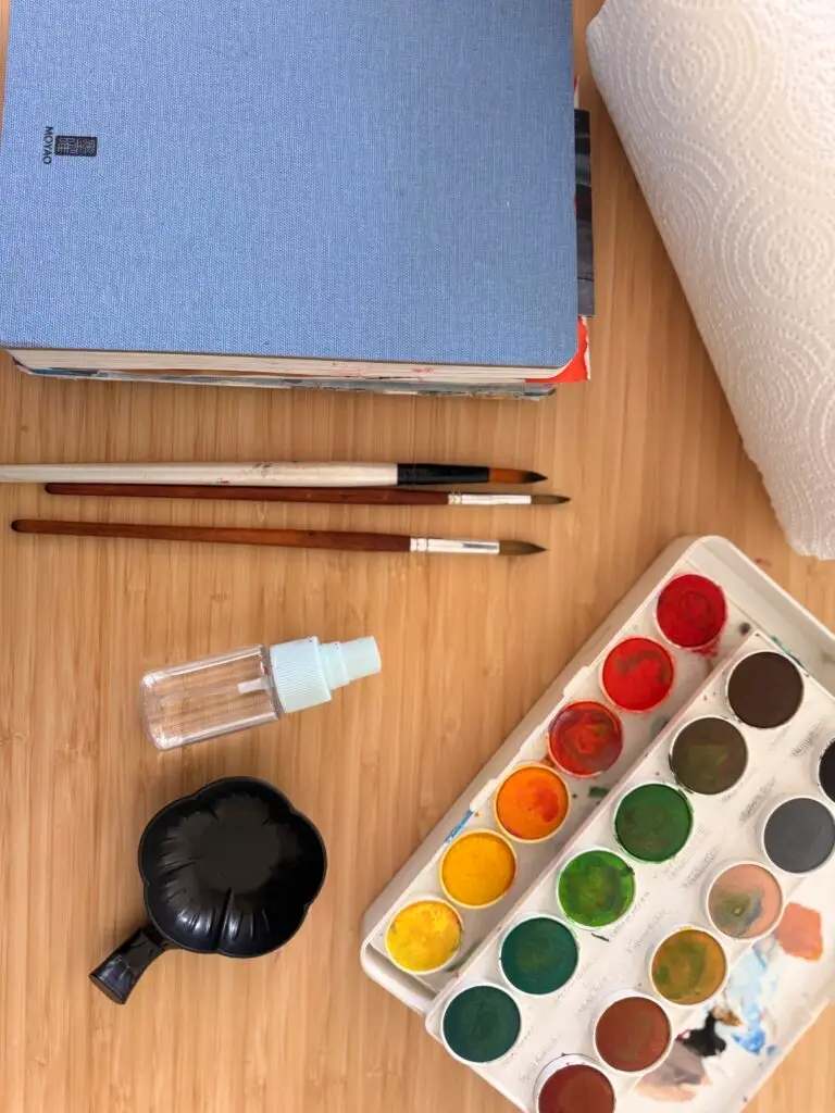 flat layout of watercolor art supplies to paint loose flowers